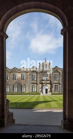 Blick durch einen Bogen der St. Salvator's Chapel, University of St Andrews, Fife, Schottland, über den gestreiften Rasen zum Eingang des Nordflügels Stockfoto