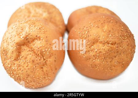 Runde, handgroße Hamburger-Brötchen, gebacken und mit Sesamsamen bedeckt, Brötchen ist eine Art Brötchen, in der Regel gefüllt mit herzhaften Füllungen, hergestellt aus fr Stockfoto