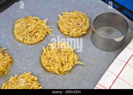 Geriebene Jackenkartoffeln, gewürzt, mit Ei gebunden, runde Form, Backblech Stockfoto