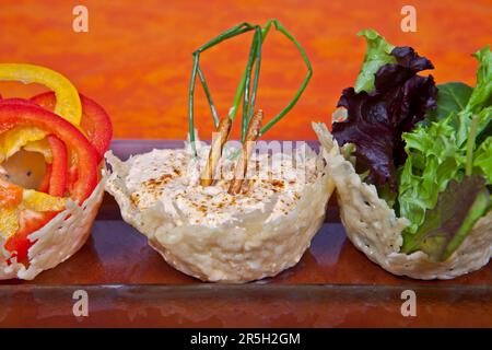 Käsedip Liptauer mit Quark und Schweizer Bergkäse, serviert mit rohem Gemüse in einem Parmesankorb, Vorspeise, rohem Gemüse, Parmesan Stockfoto