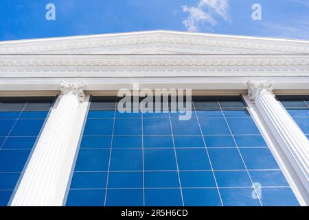 Glasturm mit einer atemberaubenden blauen Faсade und weißen Wolken am Himmel Stockfoto