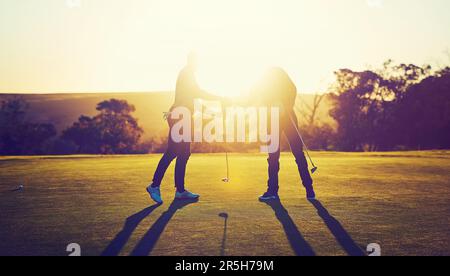 Glück ist das, was passiert, wenn Vorbereitung auf Gelegenheit trifft. Zwei Golfspieler schütteln sich die Hand auf dem Golfplatz. Stockfoto