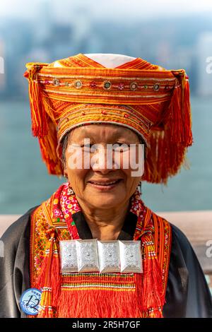 Ein chinesischer Hausbesucher in traditionellem Kostüm posiert für Ein Foto auf der Avenue of Stars, Hongkong, China. Stockfoto