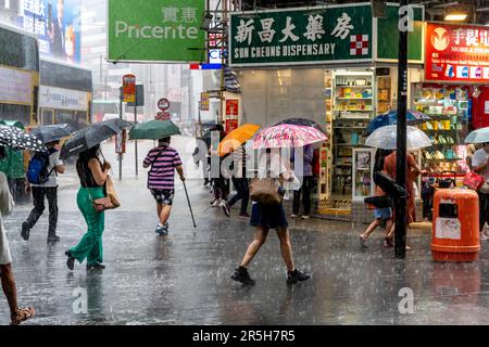 Normale Leute aus Hongkong unterwegs während Eines Gewitters, Causeway Bay, Hongkong, China. Stockfoto