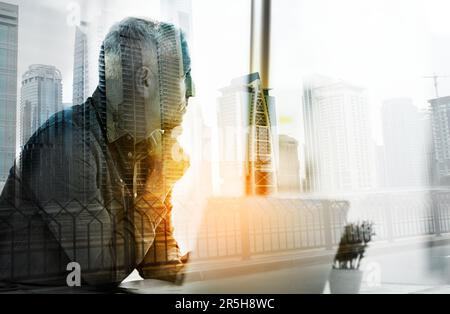 Seinen Erfolg begreifen. Ein Geschäftsmann, der in seinem Büro einen Laptop benutzt, überlagert ein Stadtbild. Stockfoto