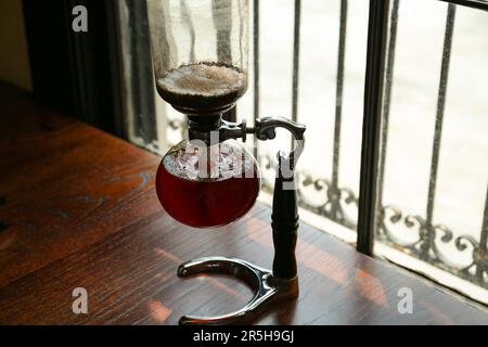 Vakuumkaffeemaschine auf Holztisch im Café Stockfoto