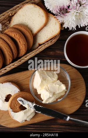 Leckere hausgemachte Butter, Kekse und Tee auf Holztisch, flach liegend Stockfoto