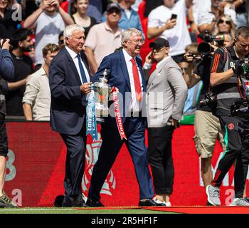 London, Großbritannien. 4. Juni 2023. Der ehemalige Spieler Mike Summerbee (L) von Manchester City und der ehemalige Manager von Manchester United, Alex Ferguson, gehen mit der Trophäe vor dem FA-Cup-Finalspiel zwischen Manchester City und Manchester United im britischen London am Juni aus. 3, 2023. Man City gewann 2:1. Kredit: Xinhua/Alamy Live News Stockfoto