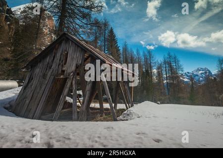 Einsam verfallende Schiefe Scheune Hütte im Schnee in den Dolomiten Italien Stockfoto