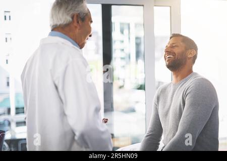 Du bist in guter Form. Ein leitender Arzt, der seinen männlichen Patienten während seiner Sprechstunde gründlich untersucht. Stockfoto