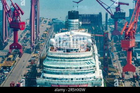 SHANGHAI, CHINA - 26. APRIL 2023 - Eine allgemeine Ansicht zeigt die Adora Magic City, Chinas erstes im Inland gebautes großes Kreuzfahrtschiff, das sich in der letzten Bauphase befindet, in Shanghai, China, 26. April 2023. Wie geplant beginnt die Adora Magic City am 1. Juni 2023 offiziell mit dem sechstägigen Andocken. Während dieses Zeitraums wird die Positionsdynamik des Kreuzfahrtschiffs durch den Landtraktor gesteuert, und es werden drei Schlüsseltests durchgeführt, darunter Neigungstests, Spültests an der Schießseite, Entkopplungstests an den Rettungsbooten und Kreuzfahrttests, um das Gewicht und den Schwerpunkt des gesamten Schiffes zu überprüfen Stockfoto