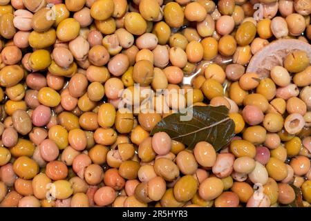 Ein Haufen grüner Oliven auf der Theke auf dem Straßenmarkt in Izmir Kemeraltı, Türkei. Stockfoto