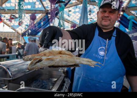 Moskau, Russland. 2. Juni 2023. Während des jährlichen gastronomischen Festivals Fish Week in der Nähe des Roten Platzes im Zentrum von Moskau, Russland, wird Fisch für Besucher gebraten. Das Festival findet in 23 verschiedenen Veranstaltungsorten in Moskau statt und findet bis zum 04. Juni statt und präsentiert verschiedene russische regionale Produkte. Stockfoto