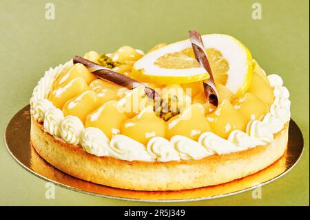 Tarte au citron, Zitronentorte dekoriert mit Sahne, Schokoladenstäbchen und ein Stück Zitrone Stockfoto