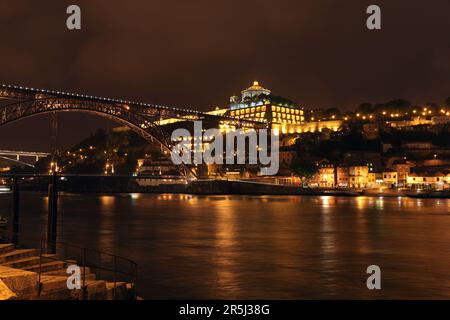 Blick auf Porto - Vila Nova de Gaia über den Douro bei Nacht. Dieses Bild zeigt den Fluss Douro und die Lagerhäuser verschiedener Portweinhersteller Stockfoto