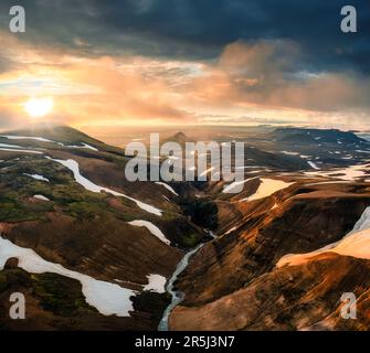 Panoramablick auf die dramatische Landschaft des Vulkans mit farbenfrohem Sonnenuntergang am Himmel im geothermischen Gebiet im Sommer im Hochland von Island Stockfoto