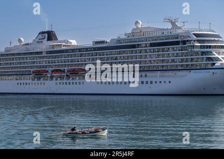 Sete, Frankreich. 27. Mai 2023. Ein Fischerboot fährt auf dem Viking Star Schiff von Viking Ocean Cruises, das im Hafen von Sete vor Anker liegt. Die einst Arbeiterstadt Sète mit ihren Werften und der Fischereiindustrie wird zu einem führenden Reiseziel. Die Gentrifizierung wird durch die Besiedlung von nomadischen Arbeitern und Künstlern beschleunigt, die die Immobilienpreise in die Höhe treiben. Kredit: SOPA Images Limited/Alamy Live News Stockfoto