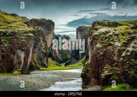 Majestätische Landschaft aus zerklüftetem Moss Fjadrargljufur Canyon mit dem Fluss Fjadra, der im Sommer im Südosten Islands fließt Stockfoto