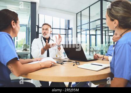 Entscheidungen über die Behandlung ihrer Patienten treffen. Ein Ärzteteam, das ein Treffen in einem Krankenhaus abhält. Stockfoto