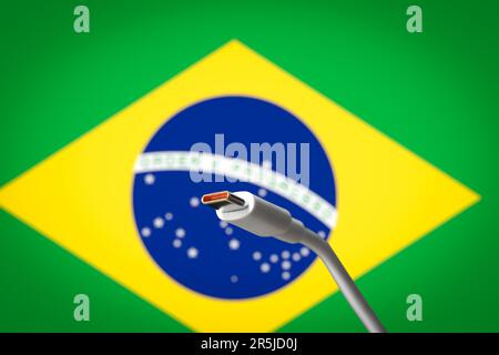 USB-C-Kabel mit der brasilianischen Flagge im Hintergrund Stockfoto