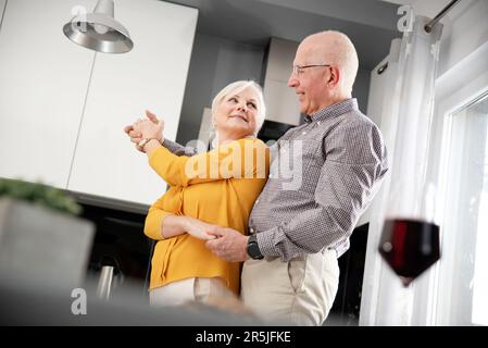 Senioren tanzen zu Hause, glücklicher Ruhestand, glückliches Seniorenpaar zu Hause Stockfoto