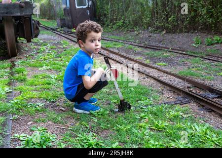 Schalterhebel für Kind auf Eisenbahnschienen Stockfoto