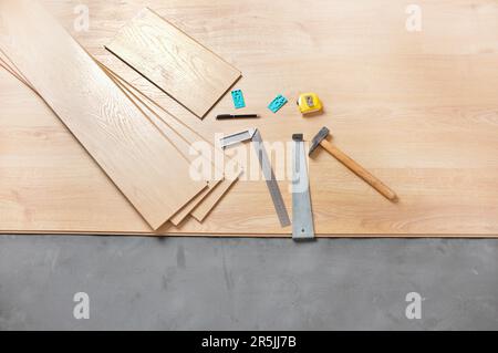 Planken von Laminatboden und Werkzeuge, um sie zu installieren Stockfoto