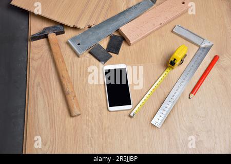 Planken von Laminatboden und Werkzeuge, um sie zu installieren Stockfoto