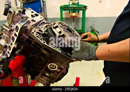 Ein Fahrzeugmotor wird auf einem Motorständer in einer Garage montiert Stockfoto