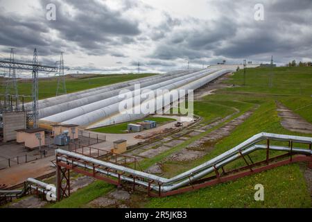 Wasserkraftwerksleitungen auf grauem Hintergrund Stockfoto