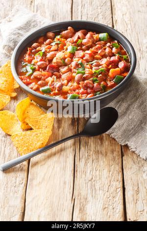 Frijoles Charros oder Charros Bohnen mexikanische traditionelle Gerichte mit Chorizo-Speck und Zwiebeln scharfe Speisen, die auf der Schüssel auf dem Tisch eingeschlossen werden. Vertikal Stockfoto