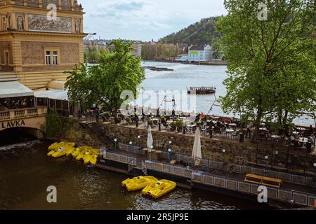 Prag, Tschechische Republik - 05.01.2023 : im Lavka Club Restaurant in Prag. Die Gäste entspannen auf der Sommerterrasse mit Blick auf die Moldau Stockfoto