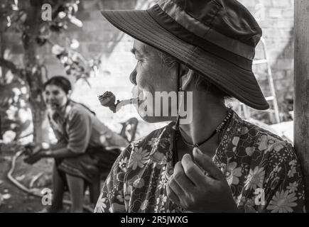 Eine Frau mittleren Alters aus der ethnischen Minderheit in Dak ME Village, Bo Ycommune, Ngoc Hoi District, Kontum Province, Vietnam, Raucht eine Pfeife. Die 200 Stockfoto