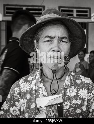 Eine Frau mittleren Alters aus der ethnischen Minderheit Kontum Province, Vietnam, raucht eine Pfeife, da sie ein Foto von ihrem Vater Holdin vor 30 Jahren besitzt Stockfoto