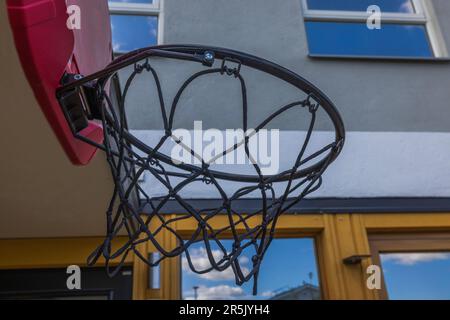 Wunderschöner Blick auf den Basketballkorb mit Netz im Garten des Hauses. Schweden. Stockfoto