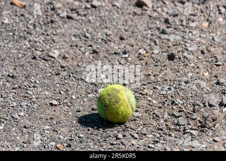 Nahaufnahme eines Tennisballs auf der unbefestigten Straße. Stockfoto