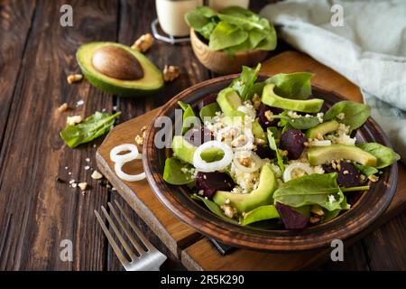 Vegane Speisen, kalorienarme Diät. Couscous mit Avocado, Rüben, grünen Bohnen, Spinat auf einem rustikalen Holztisch. Speicherplatz kopieren. Stockfoto