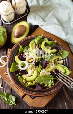 Vegane Speisen, kalorienarme Diät. Couscous mit Avocado, Rüben, grünen Bohnen, Spinat auf einem rustikalen Holztisch. Stockfoto