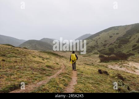 Wandern bei starkem Regen und Tragen einer Regenjacke entlang des Fisherman Trail im südlichen Teil Portugals bei Regenwetter auf dem Weg nach Cape St. Vic Stockfoto