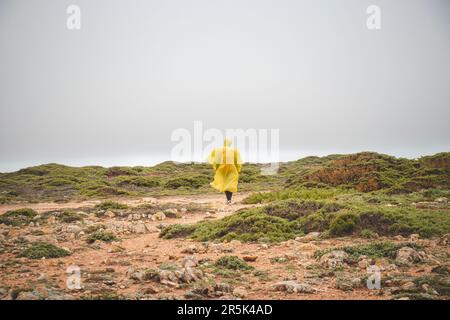 Wandern bei starkem Regen und Tragen einer Regenjacke entlang des Fisherman Trail im südlichen Teil Portugals bei Regenwetter auf dem Weg nach Cape St. Vic Stockfoto