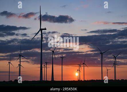 Jacobsdorf, Deutschland. 01. Juni 2023. Eine Windfarm bei Sonnenuntergang. Nach Angaben des Bundesverbands WindEnergie e.V. (Deutscher Windenergieverband) liegt der Bundesstaat Brandenburg an zweiter Stelle unter den Bundesländern mit der größten installierten Kapazität von Windkraftanlagen. Somit wird etwa ein Drittel des Strombedarfs aus Windenergie erzeugt. Kredit: Patrick Pleul/dpa/Alamy Live News Stockfoto