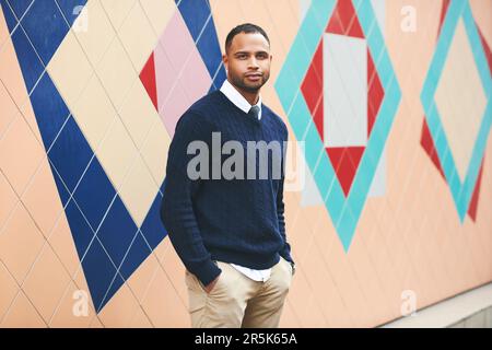 Außenporträt eines gutaussehenden afroamerikanischen Mannes mit blauem Pullover Stockfoto