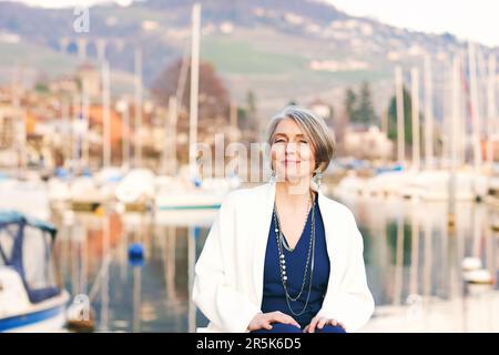 Außenporträt einer mittelalterlichen Frau, die im kleinen Seehafen ruht Stockfoto