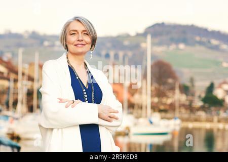 Außenporträt einer mittelalterlichen Frau, die im kleinen Seehafen ruht Stockfoto