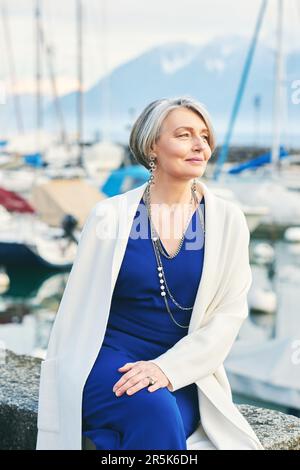 Außenporträt einer mittelalterlichen Frau, die im kleinen Seehafen ruht Stockfoto