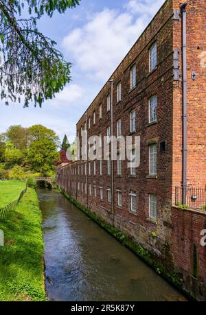 Außenansicht einer restaurierten Baumwollspinnerei und Webfabrik im Norden Englands mit Fluss Stockfoto