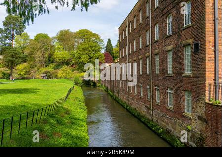 Außenansicht einer restaurierten Baumwollspinnerei und Webfabrik im Norden Englands mit Fluss Stockfoto