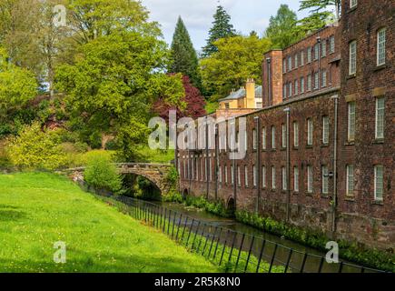 Außenansicht einer restaurierten Baumwollspinnerei und Webfabrik im Norden Englands mit Fluss Stockfoto