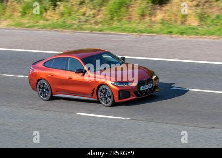 2022 Orange BMW I4 M50, 544 xDrive Electric 83,9Kwh Auto Orange Car Fatchback Electric 400 kW Fahrleistung auf der Autobahn M61, Großbritannien Stockfoto