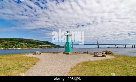 Grüner Leuchtturm von Inverness Schottland auf Carnac oder Carnarc Point, die Kessock Bridge und die Häuser von North Kessock auf der anderen Seite des Wassers Stockfoto